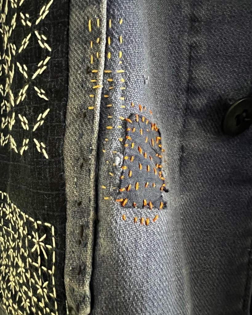 drench denim with visibly mended intentional patching in orange thread and indigo and white sashiko stitching